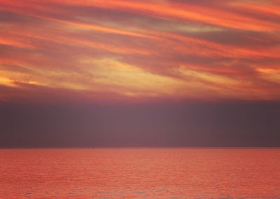 Surfer Under Fiery Sky at Montara Beach