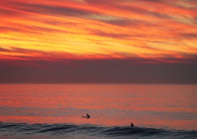 Surfers Under Fiery Sky at Montara Beach