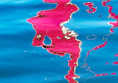 pink sail reflection distortion in the water looks like a face